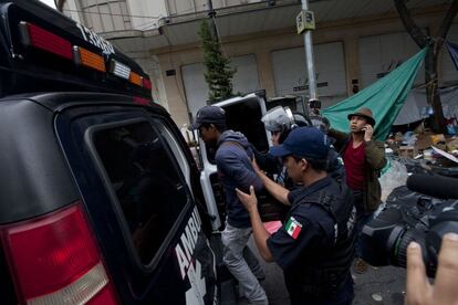 Agentes de la policía detienen a uno de los manifestantes.