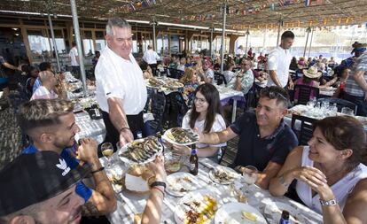 Un camarero atiende a unos clientes en un chiringuito de Málaga, este verano.