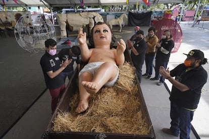 La familia Gómez Resendiz aplaude tras colocar una figura gigante del Niño Jesús durante los preparativos para las celebraciones navideñas en una plaza en el distrito de Iztapalapa, Ciudad de México, el 21 de diciembre.