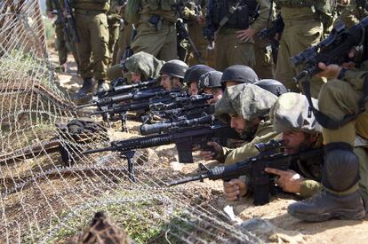 Soldados israelíes toman posiciones mientras los manifestantes cruzan la frontera desde Siria hacia los Altos del Golán, territorio ocupado por Israel, cerca de la ciudad drusa de Majdal Shams.