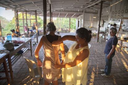 María ayuda a Elena Carmen a probarse su última confección. Su primer vestido de noche.