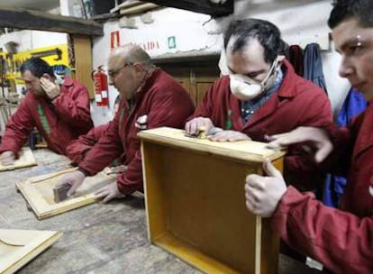 Cuatro hombres aprenden carpintería en el taller del centro de rehabilitación Lenda, que promueven las familias de Redondela.