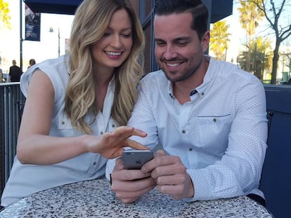 Una pareja utiliza un tel&eacute;fono m&oacute;vil.