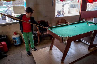 Un niño migrante juega al billar en un restaurante improvisado, en 'La Jungla' de Calais. Los migrantes se han asentado en la zona norte del campo, después de que el Gobierno francés decidiera desmantelar la del sur. El exministro conservador Xavier Bertrand, presidente de la región Alta Francia, donde se encuentra el campo, afirmó al diario 'Le Figaro' que la "degradación se acelera" en el campamento y ha pedido medidas de control.