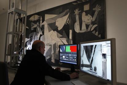 Un operario del equipo de restauración observa ayer las fotografías del <i>Guernica </i>tomadas por el robot en el Reina Sofía.