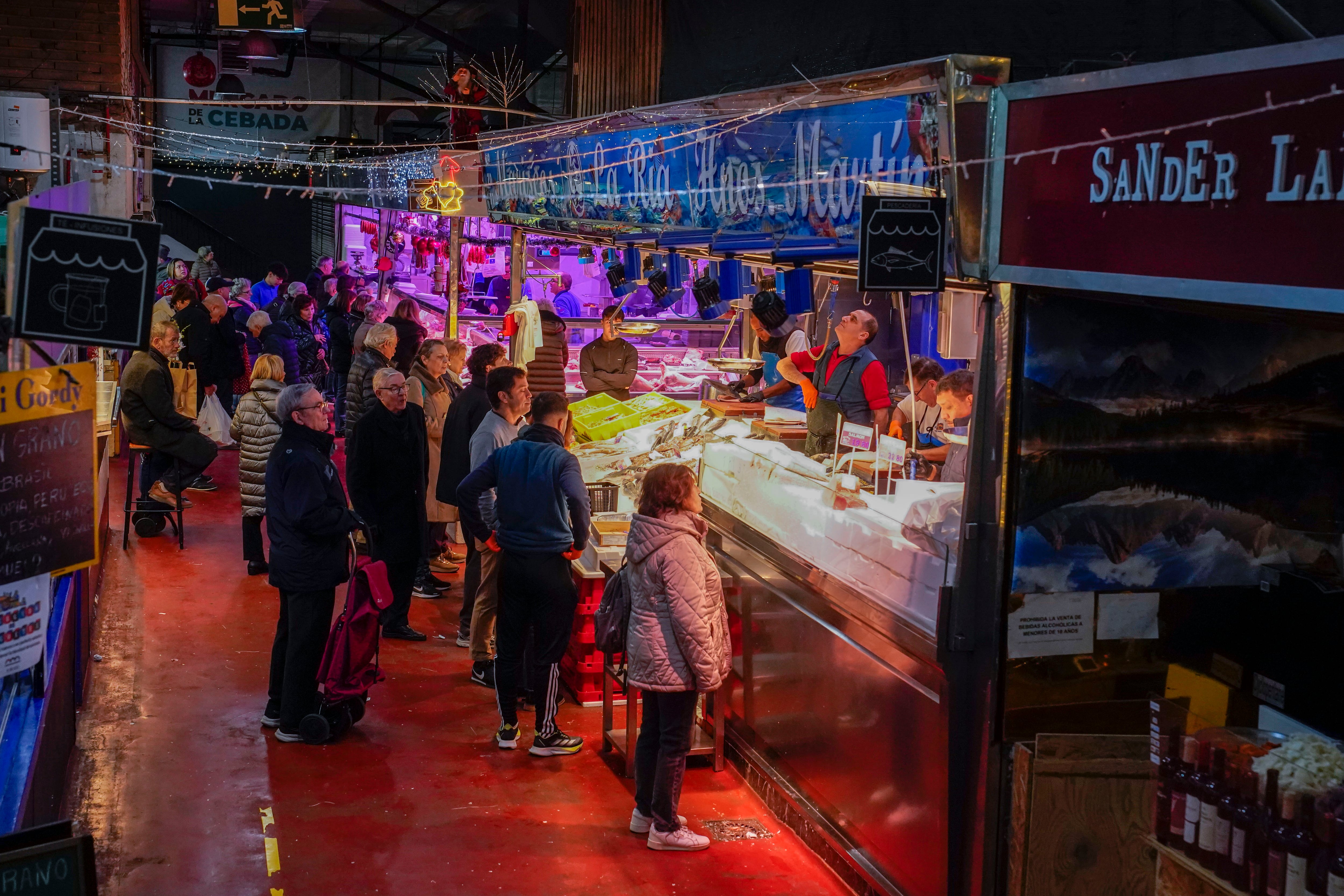 Clientes compran en el mercado de La Cebada de Madrid.