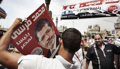 Un seguidor de la Hermandad porta un cartel del candidato Mohamed Morsi.