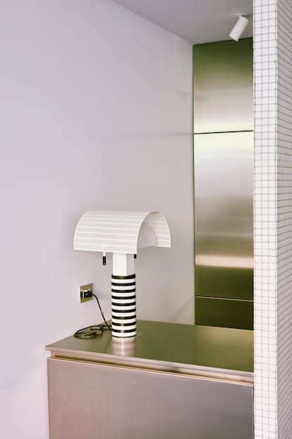 Sobre el mueble de acero que separa la cocina, lámpara Shogun, de Mario Botta.