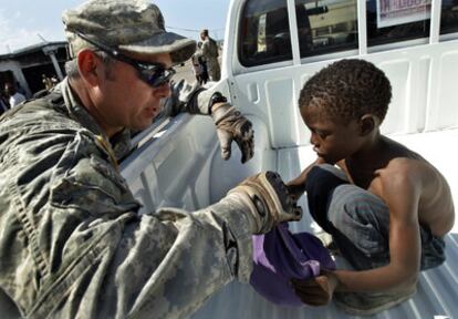 Un soldado estadounidense da una bolsa con comida a un niño haitiano