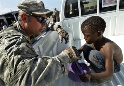 Un soldado estadounidense da una bolsa con comida a un niño haitiano
