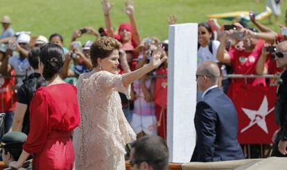 Dilma acena para militantes ao lado da filha.
