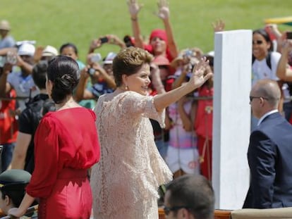 Dilma acena para militantes ao lado da filha.