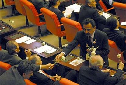 Un parlamentario turco entrega flores a un compa?ero durante el debate de ayer.