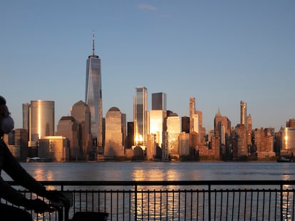 Homem pedala por uma rua deserta diante do ‘skyline’ de Manhattan.