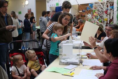 Als menuts els fa molta il·lusió introduir el vot a l'urna. Aquí, una família a l'escola Pau Romeva de les Corts.