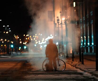 La silueta de un hombre con su bicicleta se ve recortada por una nube de vapor que sale de una alcantarilla en Milwaukee. Otra racha de aire ártico ha llegado a Wisconsin, bajando las temperaturas a dos grados bajo cero.