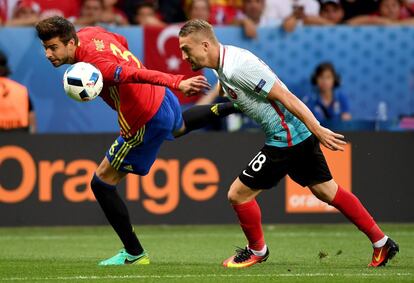 Gerard Piqué (i) y Caner Erkin intentan hacerse con la pelota.