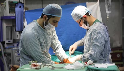 Dos profesionales sanitarios operan en un hospital sirio.