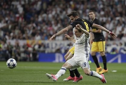 El jugador del Real Madrid Luka Modric y el del Atlético de Madrid Saúl Ñíguez luchan por el balón durante el partido.