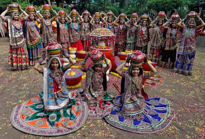 Un grupo de mujeres vestidas con trajes tradicionales posan antes de bailar Garba, un baile tradicional, al comienzo de la festividad de Navratri, en Ahmedabad (India).