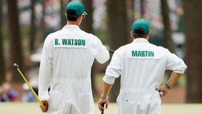 Ted Scott, caddie del actual campeón, Bubba Watson, a la izquierda, charla con su colega Alex Boyd, porteador del golfista Ban Martin, el lunes, en Augusta.