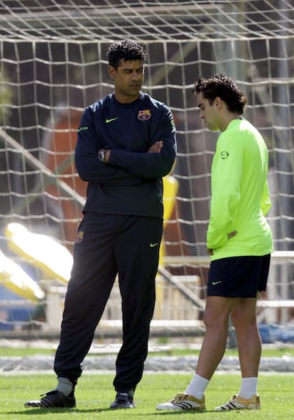 Um contundido Xavi conversa com seu então treinador, Frank Rijkaard, durante um treino do Barcelona em março de 2006.