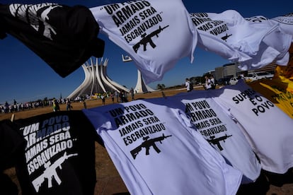 Camisetas con la frase "Un pueblo armado jamás será esclavizado", a la venta en una protesta bolsonarista en Brasilia, en julio de 2022. 
