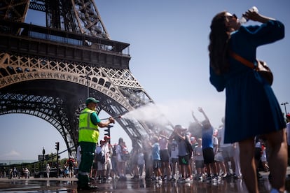 Un trabajador moja a un grupo de niños en París, este martes.