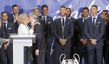 La alcaldesa de Madrid, Manuela Carmena, besa al presidente del Real Madrid, Florentino Pérez, junto a los jugadores madridistas.