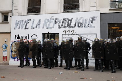 Policias antidisturbios hacen guardia frente a un graffiti que dice "Viva la República" durante la protesta contra la ley laboral, en París.