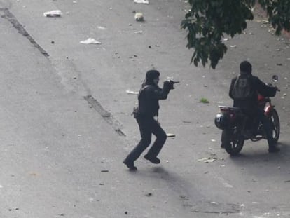 Paramilitares apontam armas para os manifestantes.