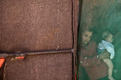 Una niña refugiada siria sostiene a su hermano menor en una tienda de campaña de un asentamiento, a las afueras de Mafraq, Jordania.