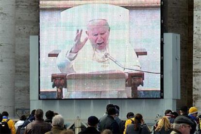 El público, transladado al aula Pablo VI, escucha a Juan Pablo II, conectado desde su biblioteca privada.