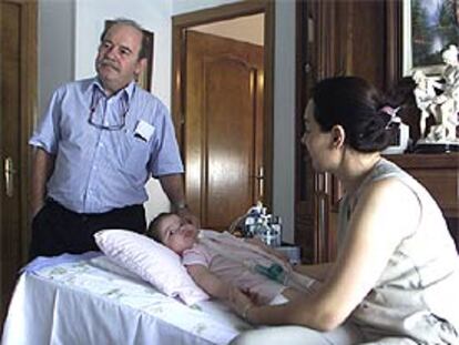 La niña María Domínguez rodeada del doctor José Luis Royo y su madre, Dori García.