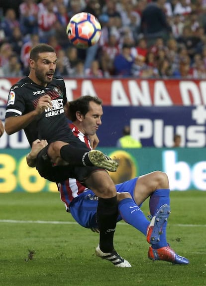 Godín lucha por el balón con el defensa del Granada David Rodríguez Lombán.