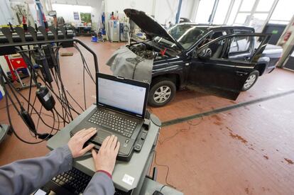 Un mecànic a Hannover (Alemanya) repara un cotxe de Volkswagen.