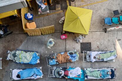 Los pacientes que muestran síntomas de Covid-19 yacen en camas fuera del Departamento de Accidentes y Emergencias del Centro Médico Cáritas en Hong Kong. El sistema médico de Hong Kong se ha sobrecargado por el brote de Covid-19 de la quinta ola, mientras que las autoridades han informado más de 1.600 casos confirmados y 5.400 infecciones sospechosas este martes.