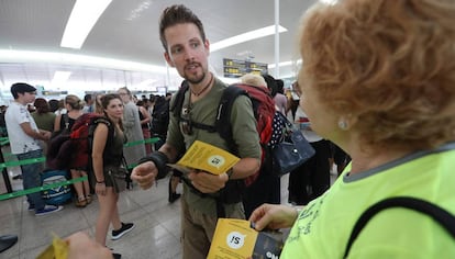 Voluntarios de la ANC reparten folletos pidiendo el 'sí' a la independencia en las colas de El Prat