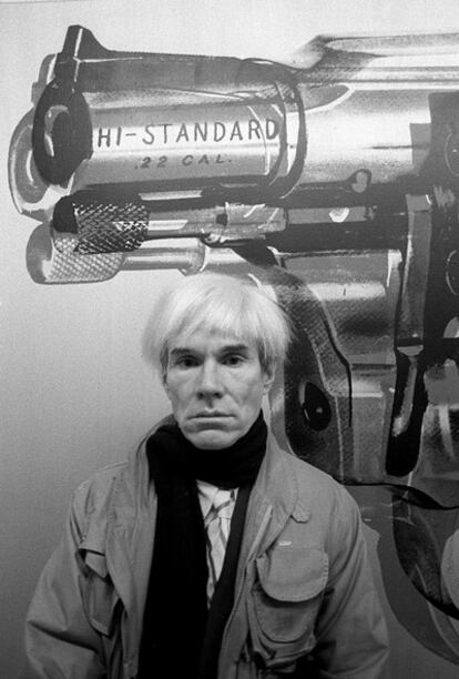 El artista estadounidense Andy Warhol posa delanta de una de sus obras en la galeria Vijande de Madrid, en enero de 1983.