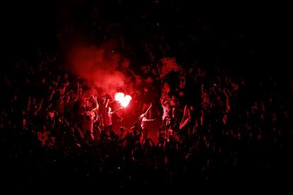 Un grupo de aficionados enciende unas bengalas mientras esperan la llegada del equipo blanco para celebrar el título de ganadores de Copa.