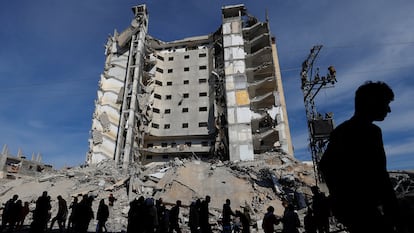 Varios palestinos caminan este sábado frente a un edificio dañado por un ataque israelí en Rafah, en el sur de Gaza.