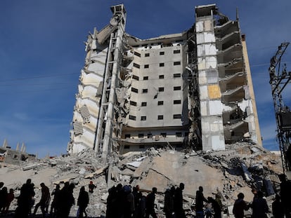 Varios palestinos caminan este sábado frente a un edificio dañado por un ataque israelí en Rafah, en el sur de Gaza.