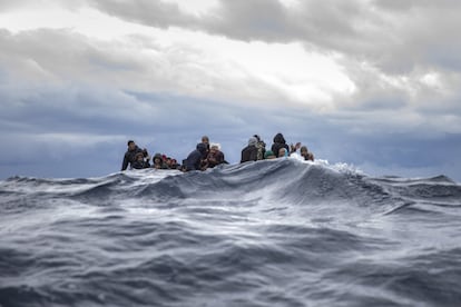 Inmigrantes provinientes de Marruecos y Bangladesh reaccionan ante la llegada de los trabajadores humanitarios de la ONG española 'Open Arms' en el mar Mediterráneo frente la costa libia, este viernes.