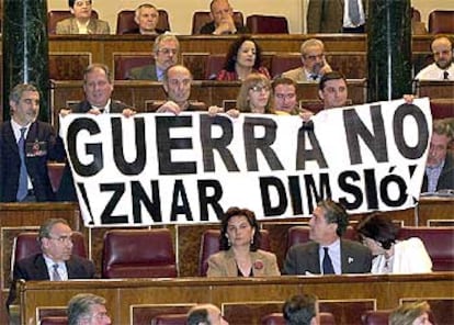 Los diputados de IU sostienen una pancarta contraria a la guerra durante la intervención de José María Aznar.