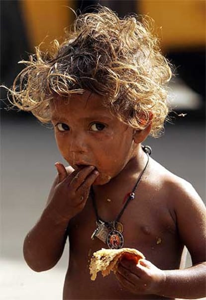 Un niño se alimenta de la basura que ha recogido en el suelo de las calles de la ciudad india de Nueva Delhi.