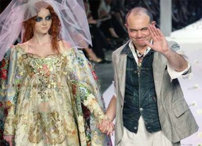 El diseñador Christian Lacroix, junto a uno de sus modelos durante el final de un desfile en París.