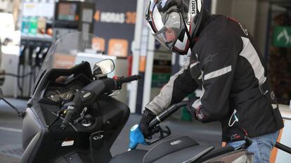  Un hombre echa gasolina a su moto.