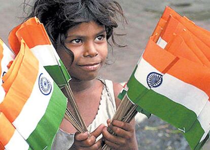 Una niña vende banderas nacionales de papel por las calles de Bombay.