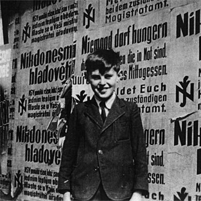 Petr Ginz, en 1940, ante un muro con carteles del Reich invitando a los judios de Praga a registrarse.