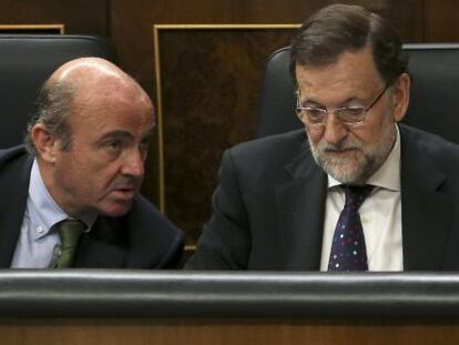 El presidente del Gobierno, Mariano Rajoy (d), junto al ministro de Econom&iacute;a, Luis de Guindos (i), en un  pleno del Congreso.